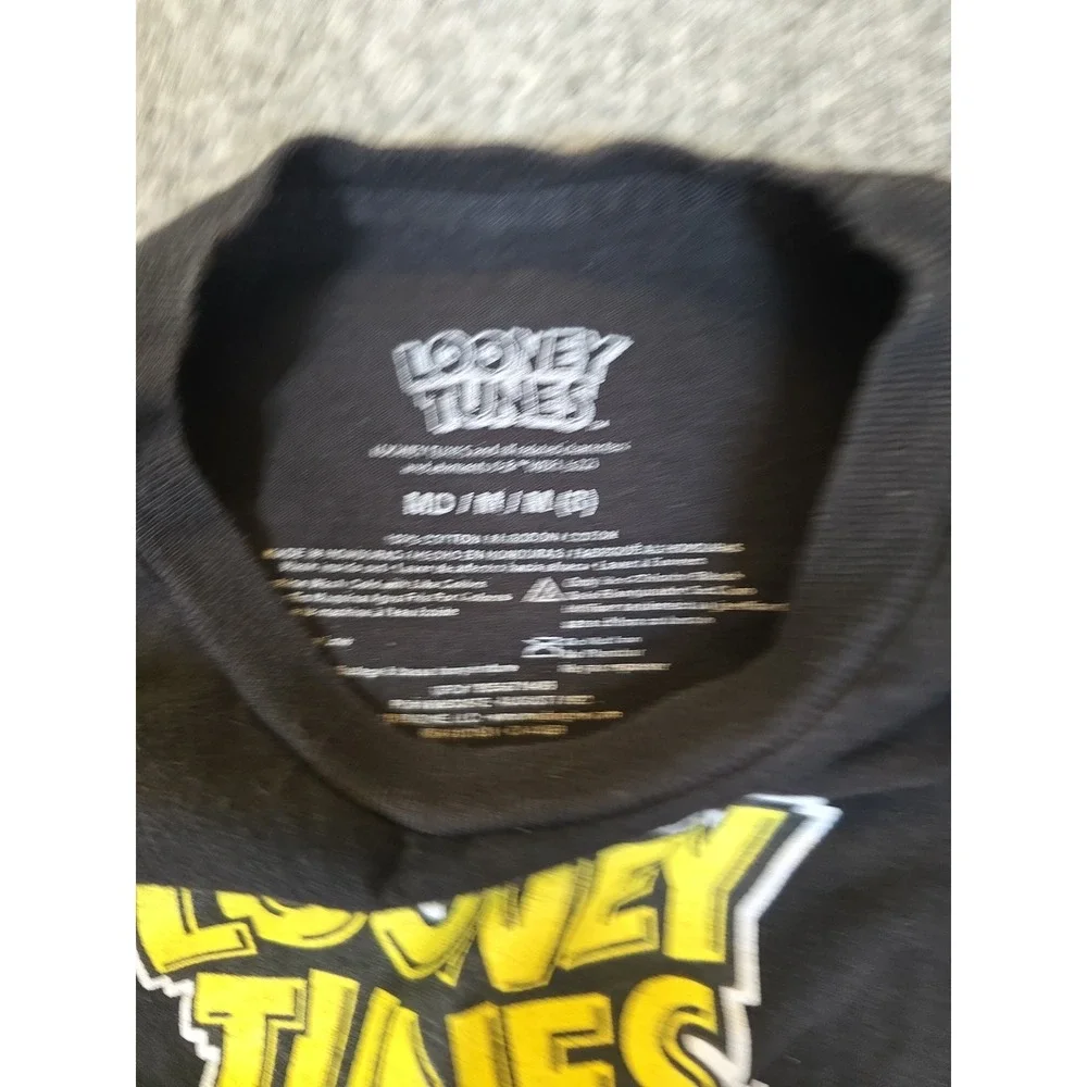black Looney Tunes t-shirt features a graphic of Bugs Bunny, Wile E. Coyote,...